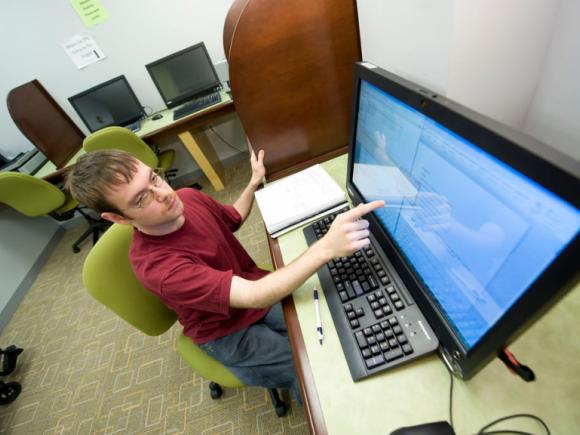 male student using touch screen computer in the Banacos Center