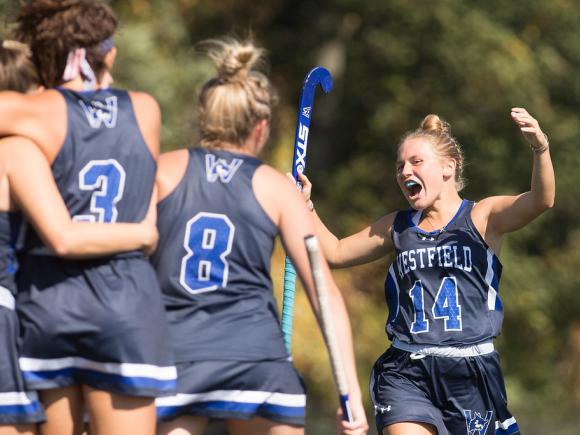 Members of the women's field hockey team celebrates after scoring a goal