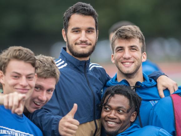 Members of the WSU men's soccer team gather and mug for the camera after a training session