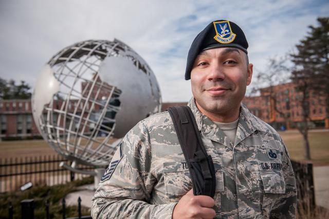 Image of student veteran in uniform in front of the globe on the campus green