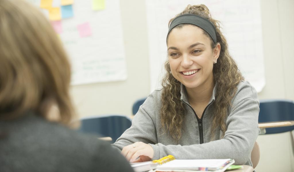 Image of female student smiling at classmate
