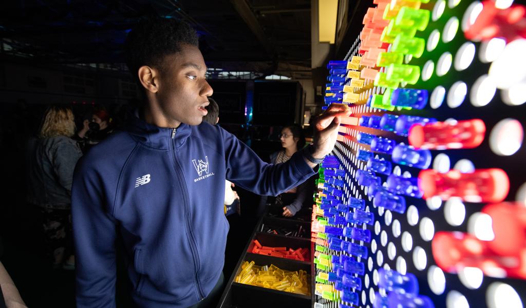 Male student plays with a light display during Spring Weekend Activities