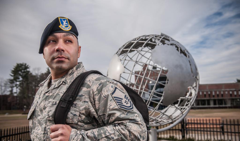 Photo of male service member, in uniform, in front of the globe on the campus green